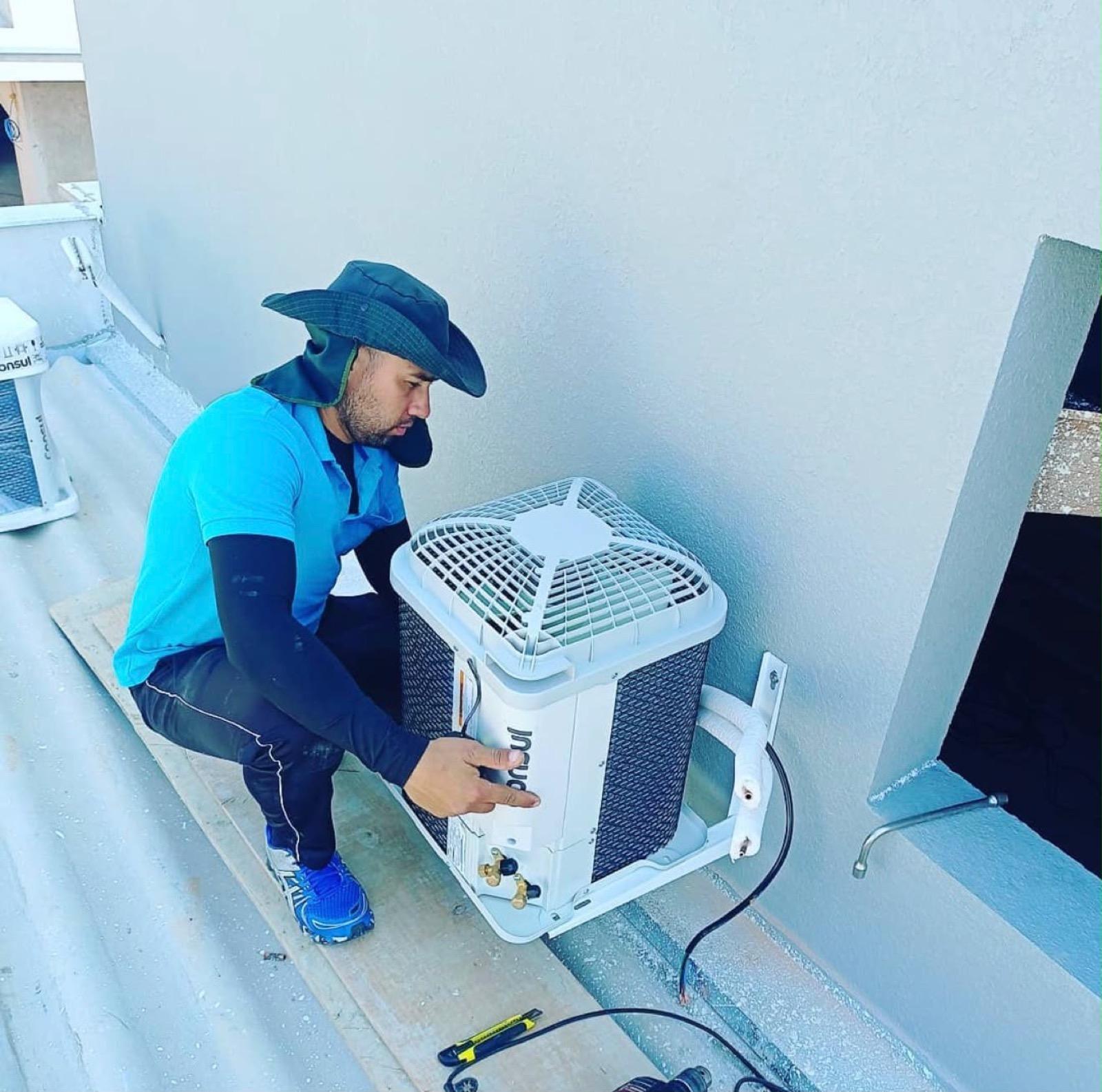 Técnico da JG Refrigeração instalando unidade externa de ar-condicionado
